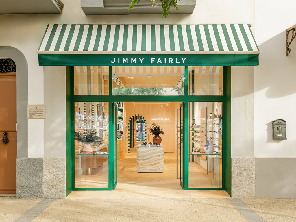 Storefront with green and white striped awning and 'Jimmy Fairly' sign.